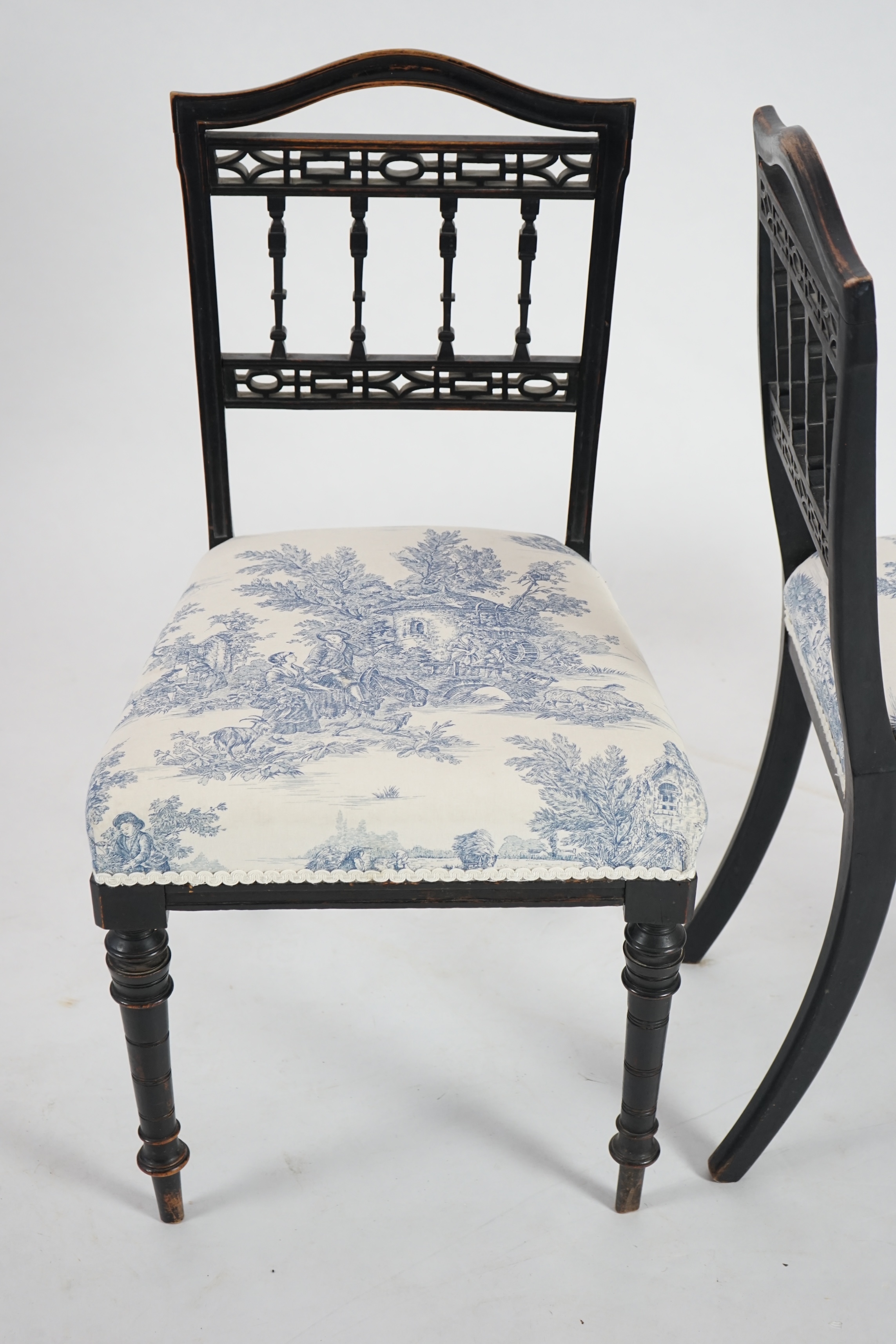 A pair of late Victorian ebonised salon chairs